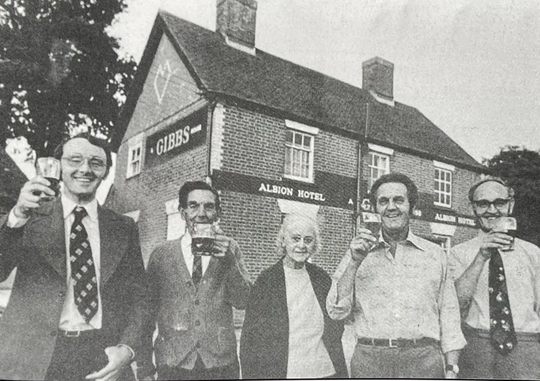 Five people raise their glasses outside the Albion Hotel